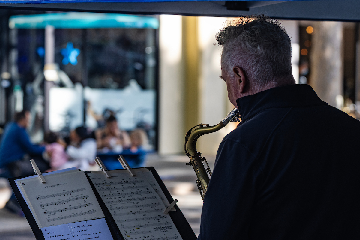 Picture of a saxophone player in Downtown Mountain View performing for a small crowd