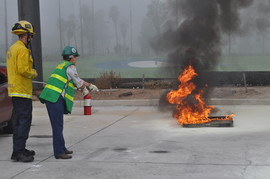 Photo of CERT instructor showing trainnee how to extingush a fire.