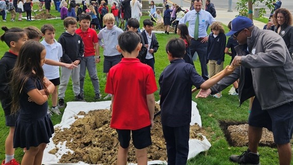 Image of students planting tree soil
