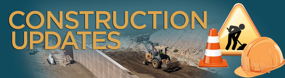 Banner reading 'Construction Updates' with a view of a safety cone, hard hat, and man working sign over an acticve construction site.
