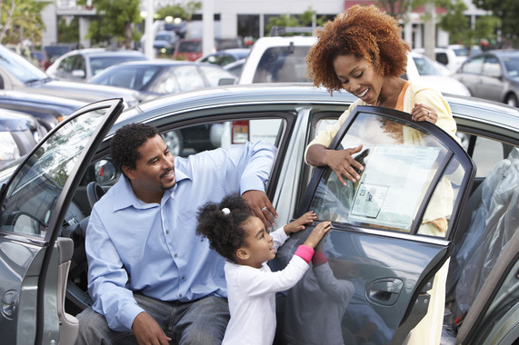 Picture of family looking at new car