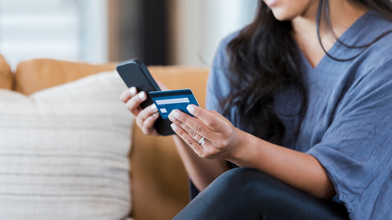 Woman using credit card on phone