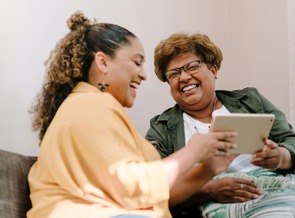 photo of two people looking at a tablet and smiling