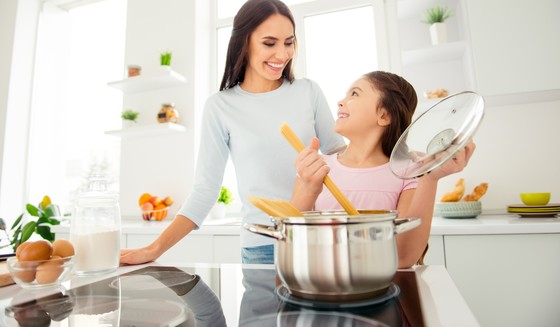 Mother and daughter cooking on induction cooktop