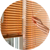 person closing window blinds