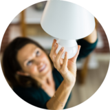 woman changing smart lightbulb