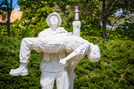 Photo of a statute solider carrying a fallen comrade and looking up to the sky. 