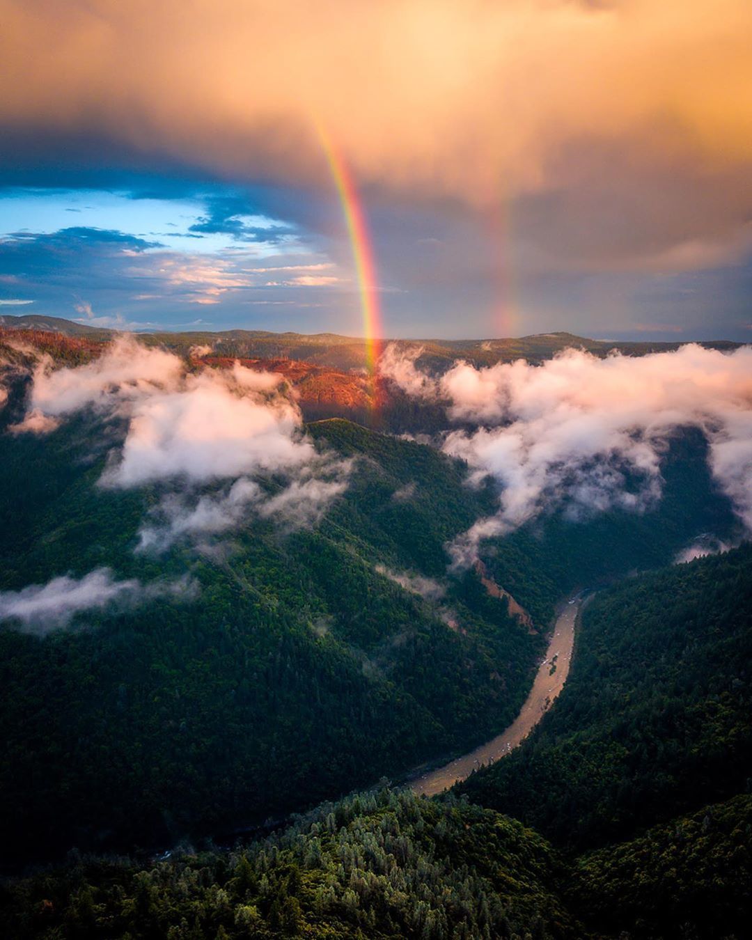 Areal photo of two rainbows over the Foresthill Divide of the American River at sunset. 