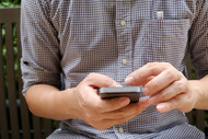 Photo of a man holding a cellphone. 