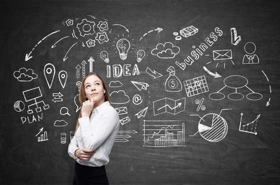 Woman standing in front of brainstorming diagram on chalkboard