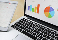 portable computer with a graph on the screen and a smart phone beside 