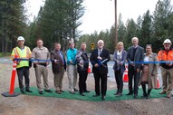 Ribbon cutting ceremony with a group standing of government officials from Placer County on a carpet near a road