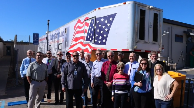 Supervisor Holmes with other staff in front of a mobile kitchen
