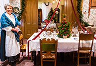 Elderly woman next to a Christmas decorated table