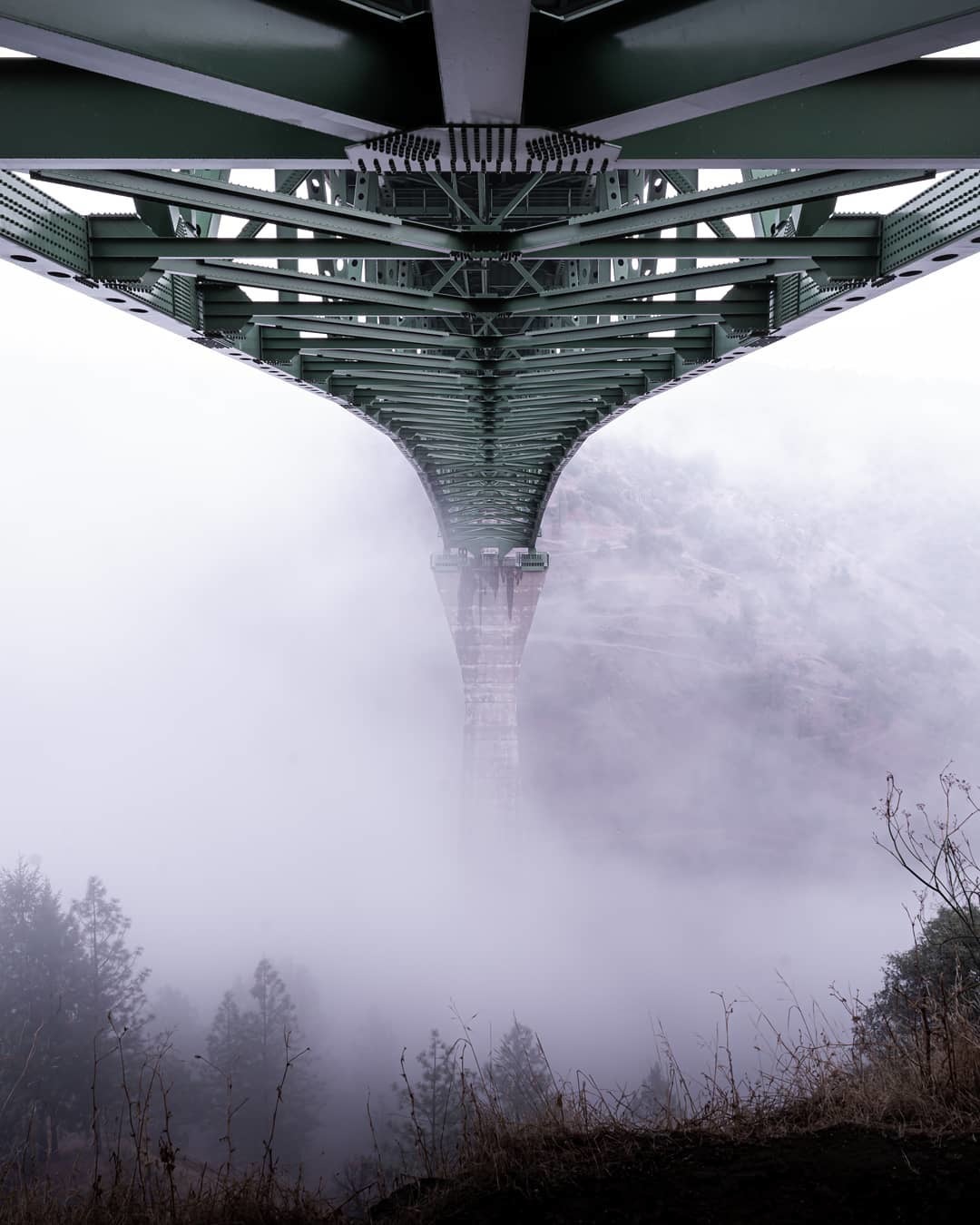Underside view from base of bridge with rolling fog 
