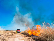Fire engine in a burning field of tall grasses