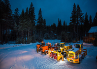 Photo of snow removal equipment at night. 