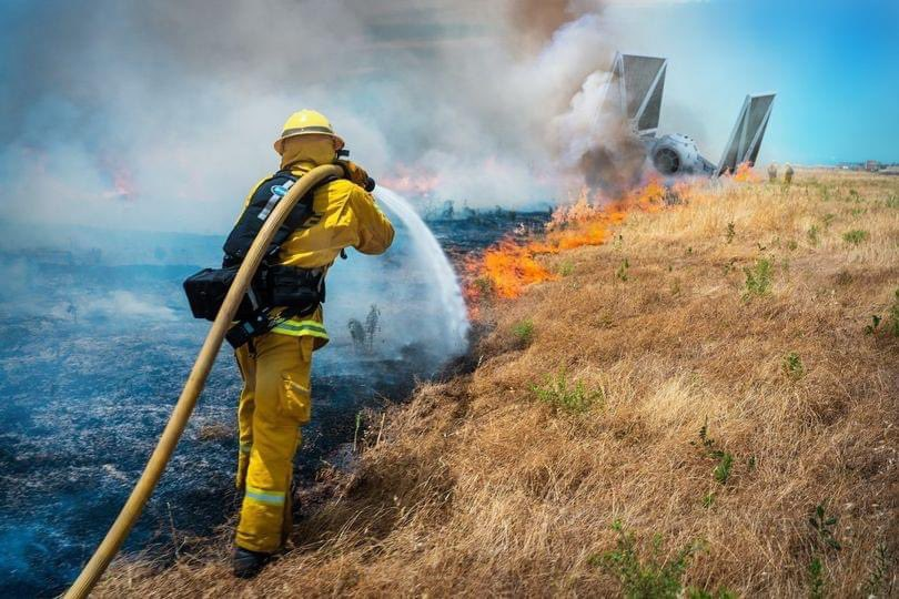 A Firefighter water hosing a big fire