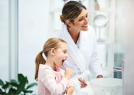 mother and daughter brushing their teeth