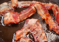 Crispy bacon sizzling in bacon fat