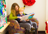 mother and child reading a book in a library
