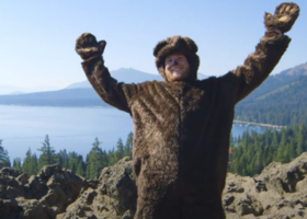 Grown man in a bear costume overlooking Lake Tahoe