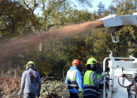 Crews clear area with chipper machine
