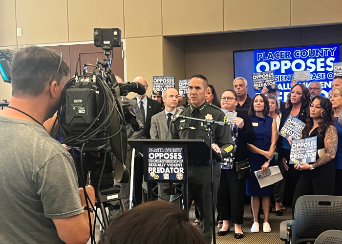 Sheriff Wayne Woo with a crowd of officials and residents speak at state hearing in protest.