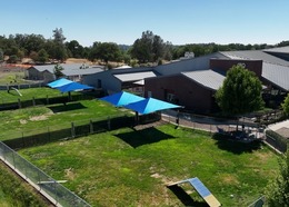 Blue sun shades cover grassy outdoor dog space at Placer County Animal Services