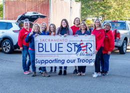 Members of Sacramento Blue Star Moms pose with "Supporting our Troops" banner