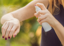 Woman uses bug spray on her arm