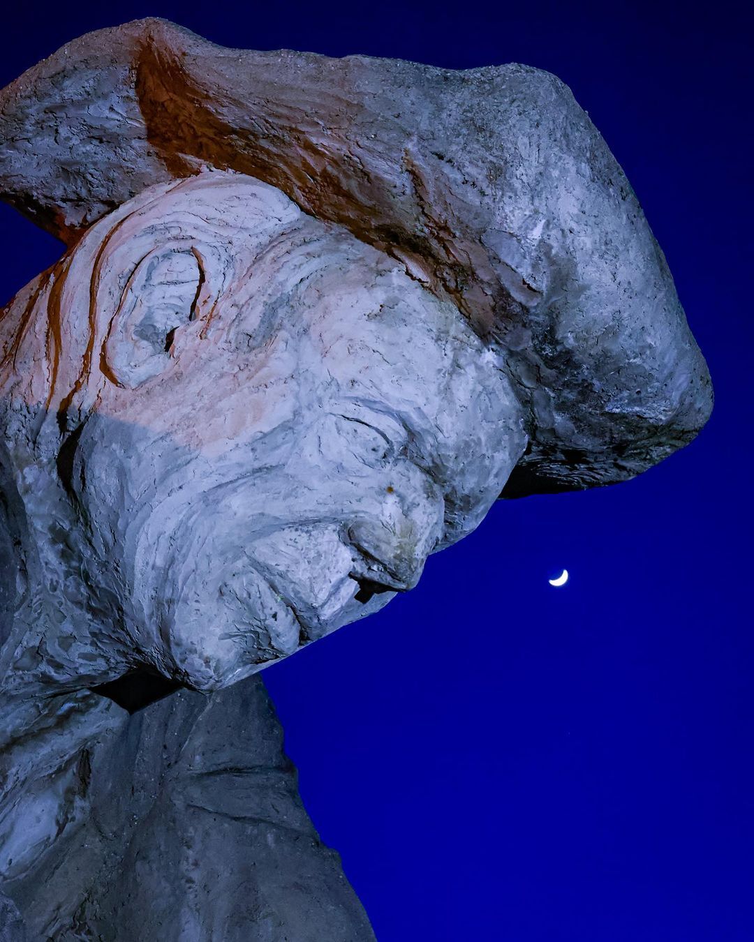 Statue of man with moon in background