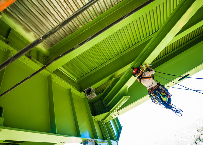 Man hanging from bridge