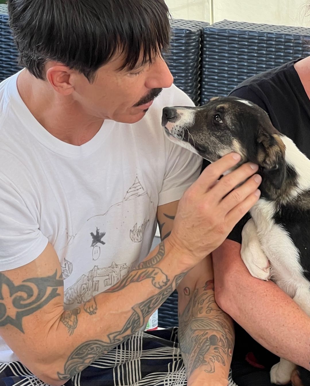Image of from  Red Hot Chili Peppers' Instagram of man holding puppy
