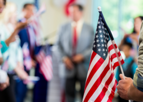 blurry image of man in suit with an American Flag in the foreground