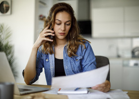 Broadband - slow wifi issues - image of woman on cellphone looking at papers