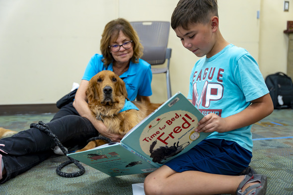 Child reading to a dog