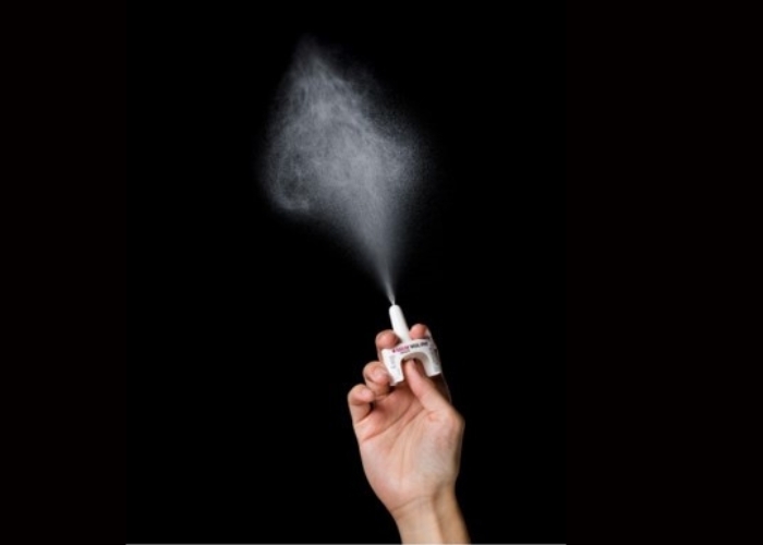 a hand holding a narcan spray