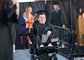 man in cap and gown at graduation