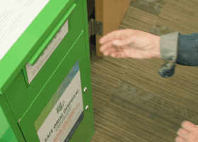 someone putting medication in a bin