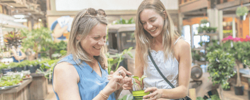 Two women buy a plant as text appears stating Saturday Nov. 30 is Small Business Saturday.