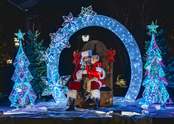 A child on santa's lap with colorful decorations 