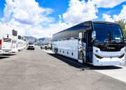 A white bus from My Ride to Work LLC in a parking lot. 