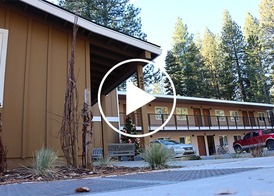 An exterior photo of the newly-renovated Brown Bear Studios in Kings Beach with a play button overlay.