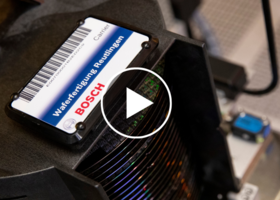 A stack of semiconductors made of silicon carbide with a Bosch manufacturer sticker and a play button overlay.