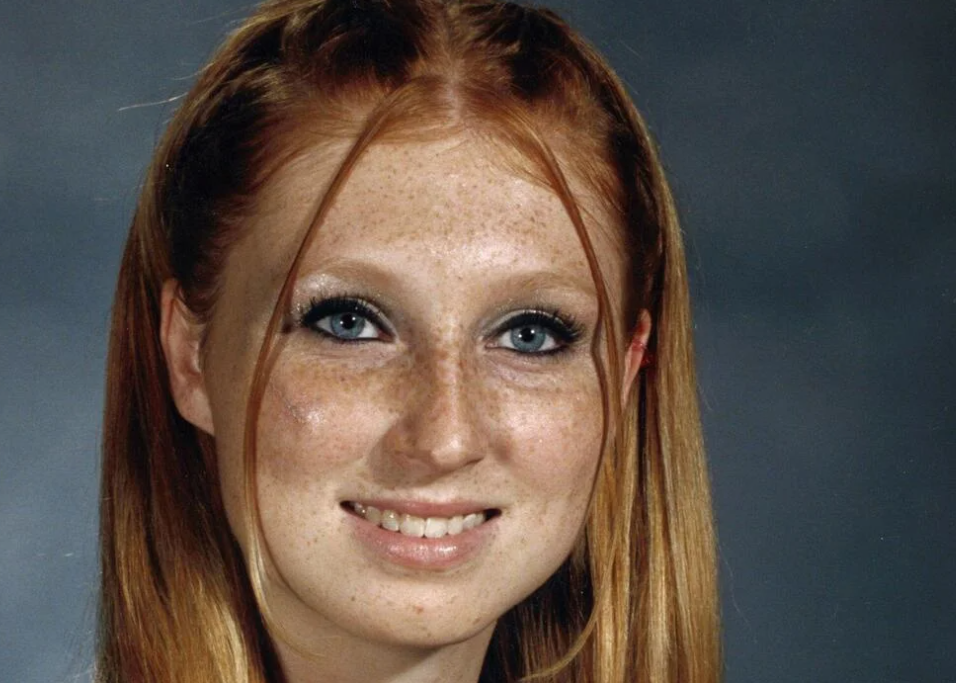 A school portrait of Justine Vanderschoot as a teenage smiling at the camera.