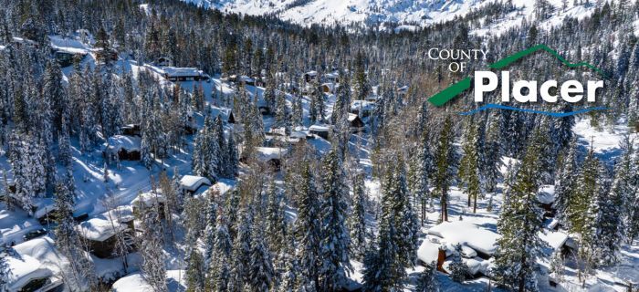 An aerial image of winter time in Tahoe with houses covered in snow.