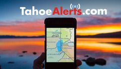 An image of a person holding a phone in front of an orange Tahoe sunset with text: TahoeAlerts.com