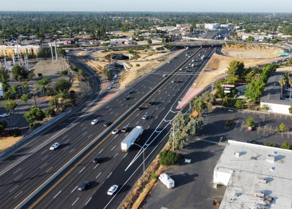 Skyview of highway with cars and trucks driving on it.