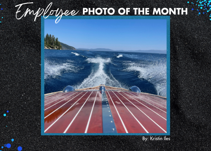 An employee-submitted photo of a boating day on Lake Tahoe with a wooden hull and waves following a boat under a blue sky.
